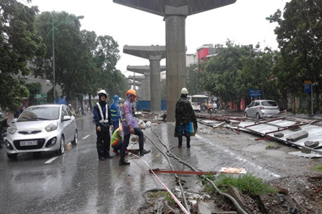 Lực lượng chức năng đang khắc phục tình trạng các tấm kim loại được chắn cho công trình đường sắt trên cao bị đổ trên đường Xuân Thủy