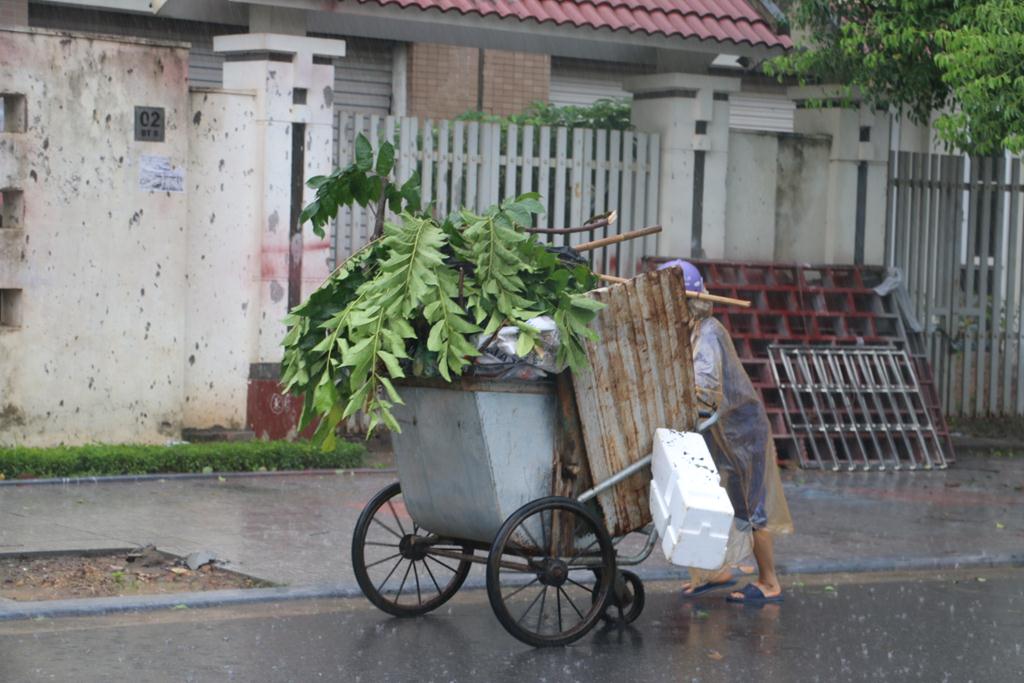 Thương người dọn rác với dáng đi lẫm lũi đầy nhọc nhằn trong mưa bão để đẩy những chiếc xe chở đầy rác, lại thêm nặng trĩu bởi những cành cây gẫy và cả… nước mưa